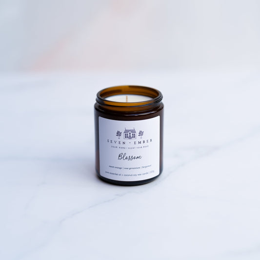 Blossom candle in an amber jar on a marble surface