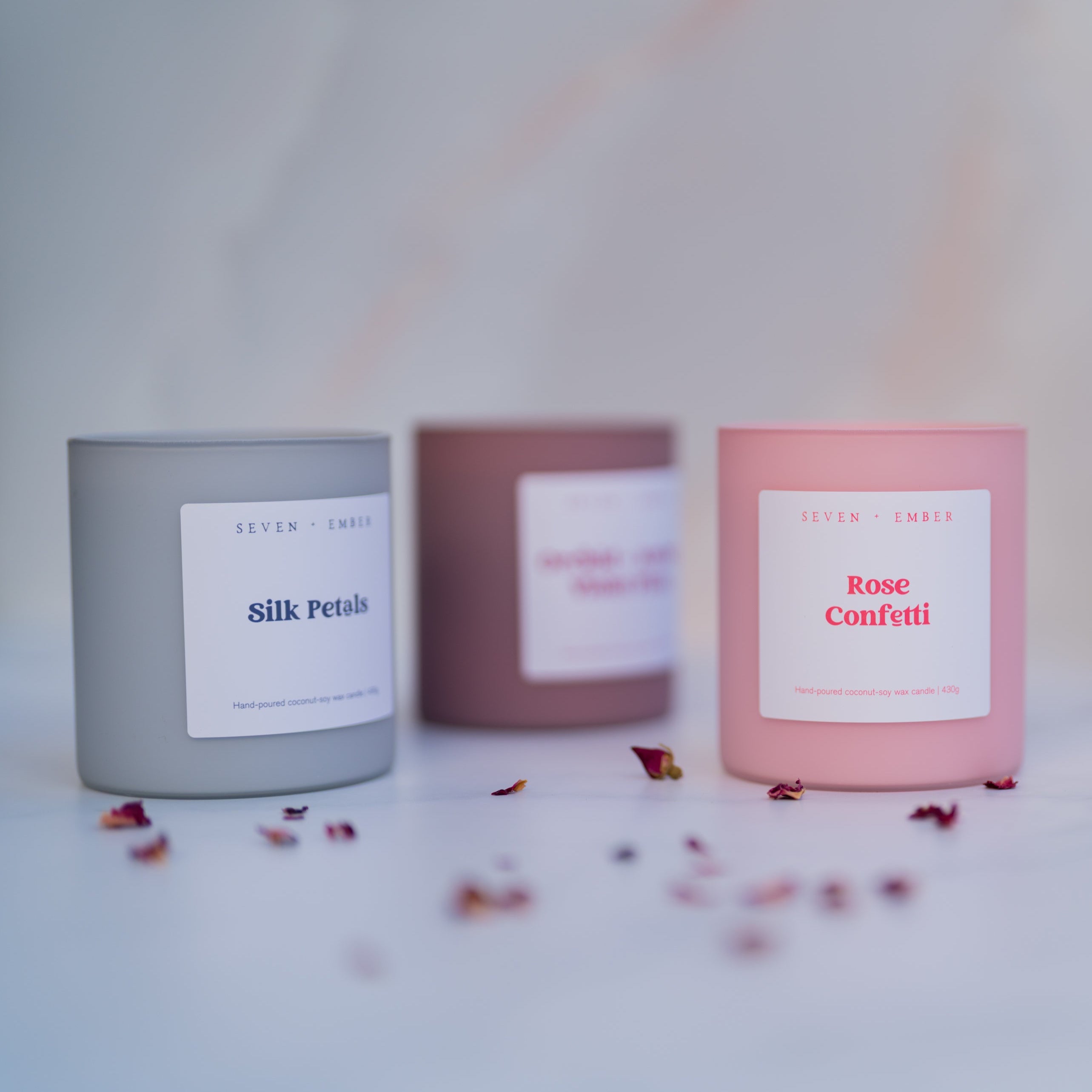 Candle with 'Rose Confetti' label on a light background with scattered petals.