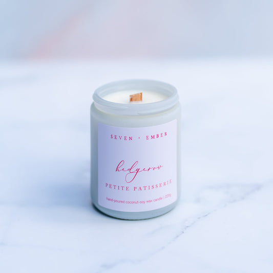 Hedgerow candle with a wooden wick in a white screw top jar on a marble surface