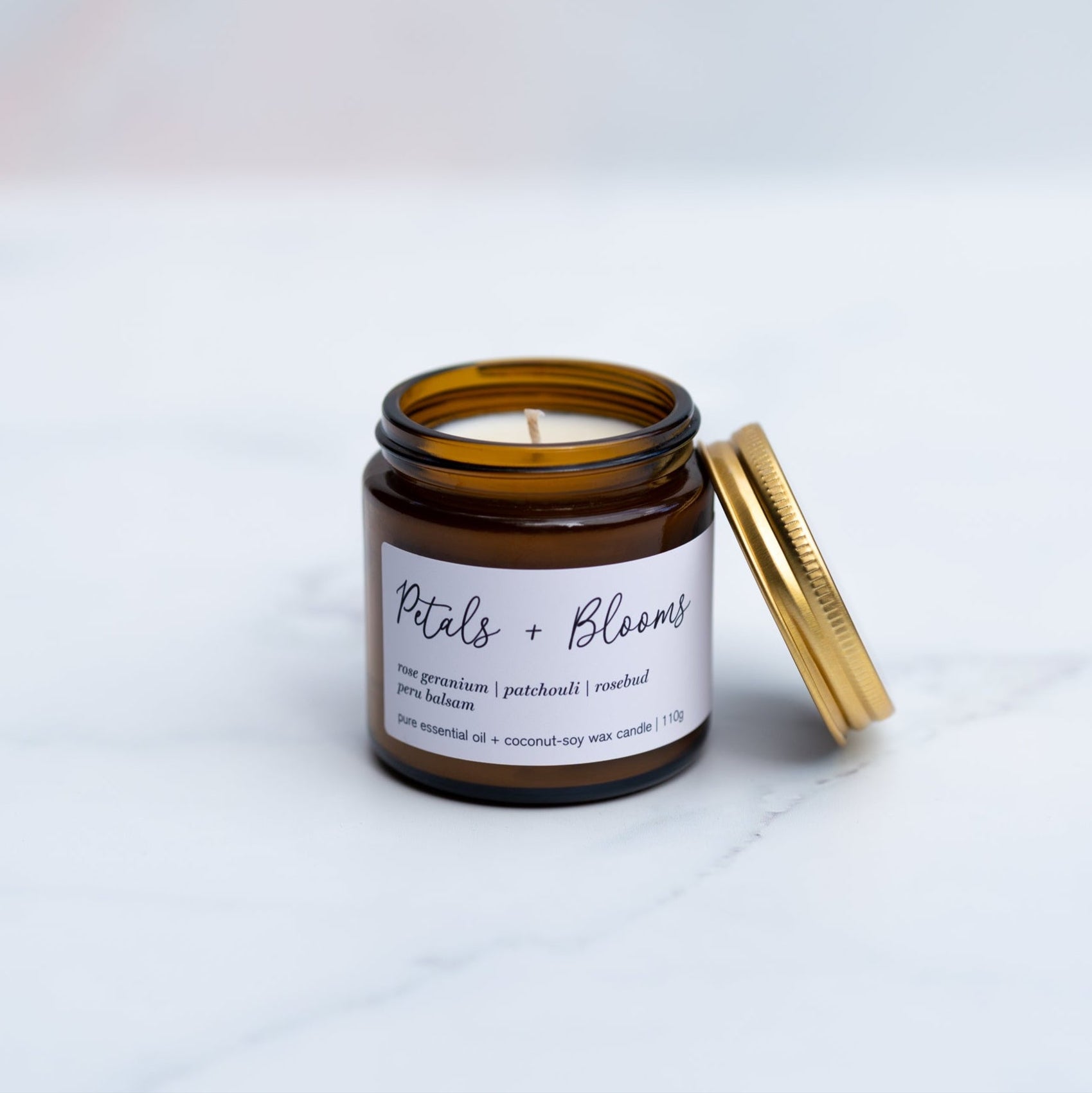 Mini Petals and bloom candle on a marble surface with gold lid