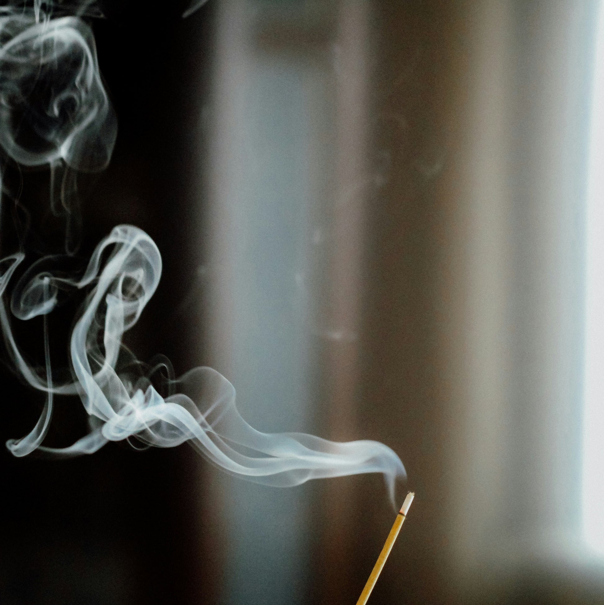 Incense burning with scent wafting up from the incense stick