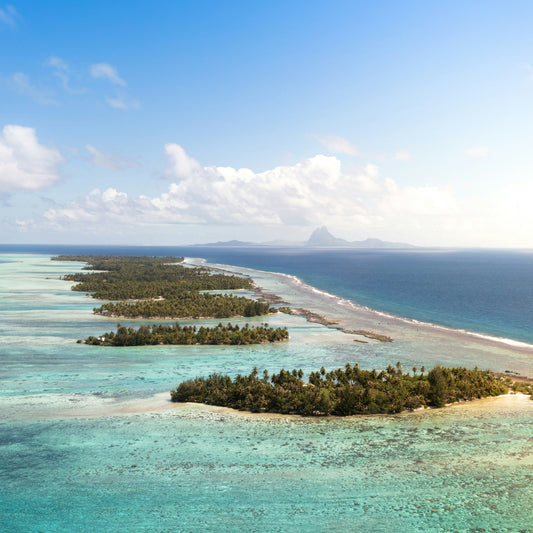 Islands surrounded by clear blue waters and a blue sky