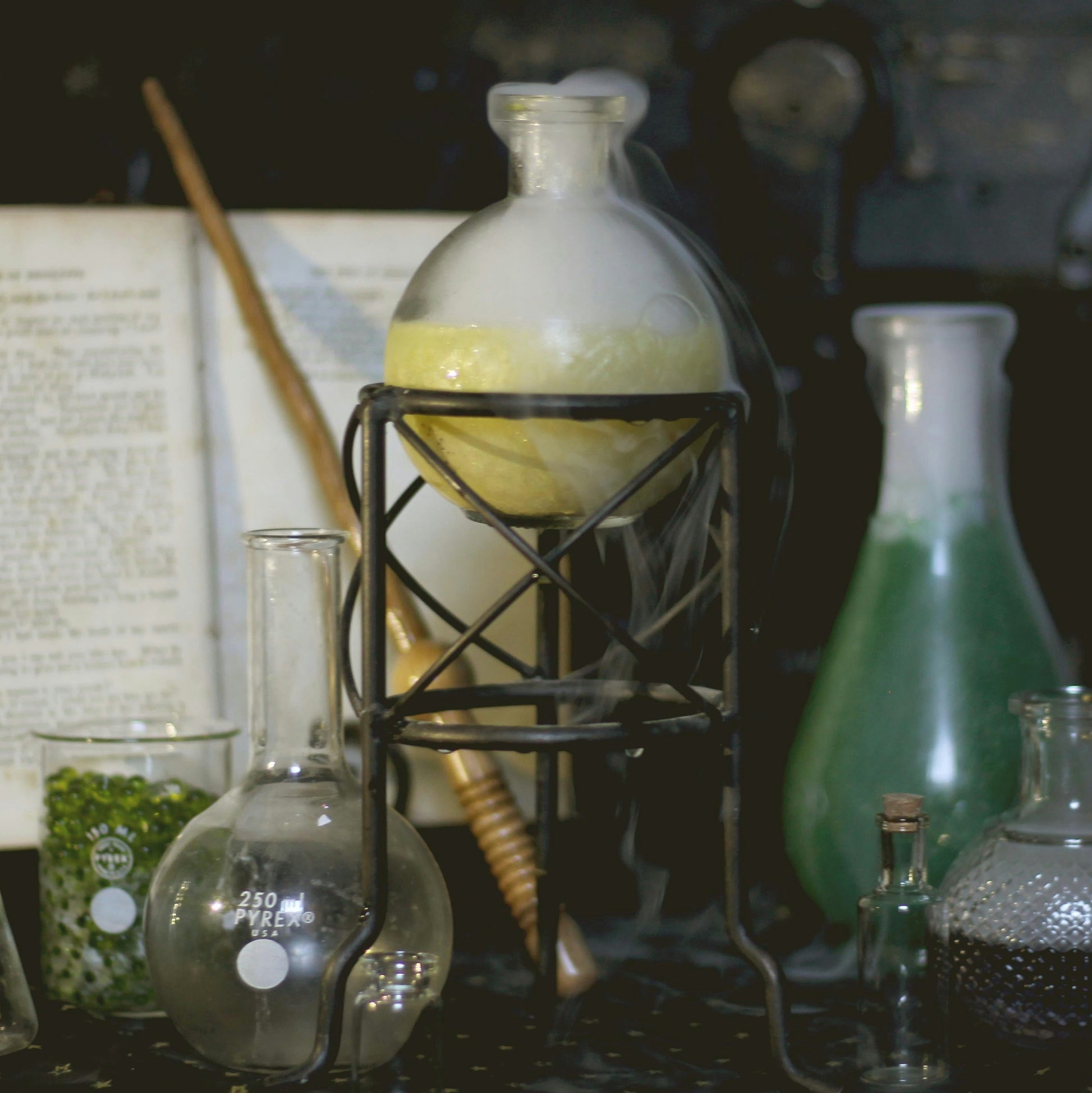 Science beakers filled with potions and a book and a wand