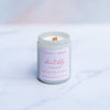 Chantilly cream candle with a wooden wick in a white screw top jar on a marble surface
