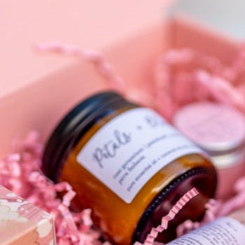 A mini Seven and Ember candle in a pink gift box with a soap