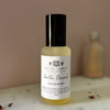 Bottle of vanilla caramel room spray mist on a marble surface against a pink blurred background