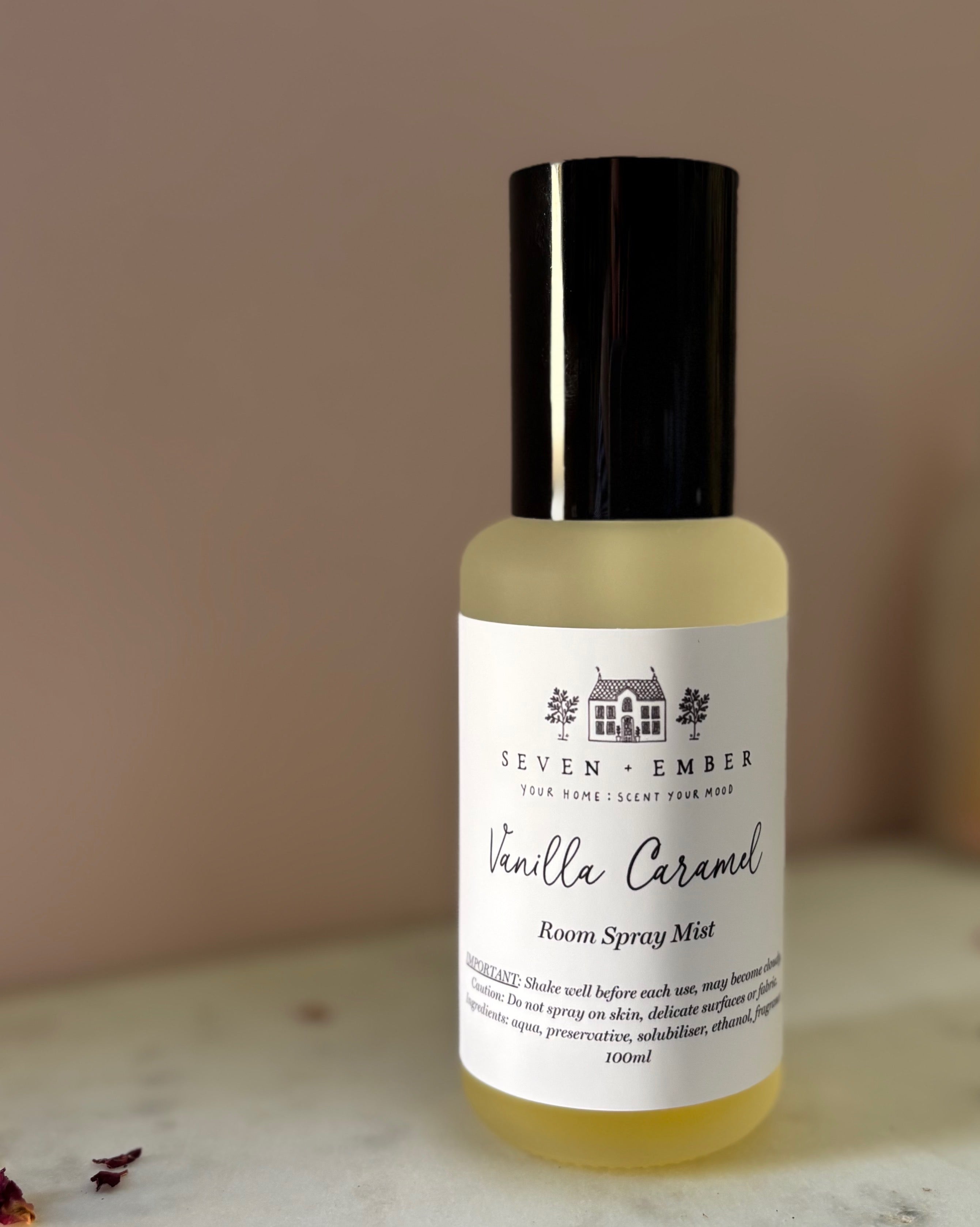 Bottle of vanilla caramel room spray mist on a marble surface against a pink blurred background