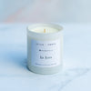 La Luna mood story candle in a white vessel on a blurred marble background