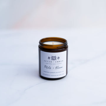Regular sized Petals and bloom candle sitting atop a marble surface