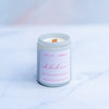 Rhubarb noir candle with a wooden wick in a white screw top jar on a marble surface