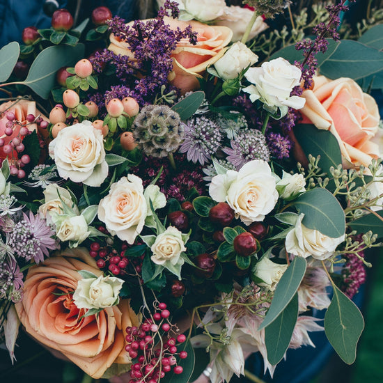 Bouquet of native blooms with eucalyptus leaves, lavender, peach roses, vanilla roses and native flowers and berries 