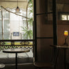 A table and chairs in front of a window in a Paris street cafe