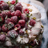 Raspberry and pistachio topped cake with icing sugar