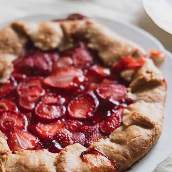 Baked strawberry galette pie on a white plate