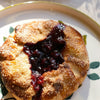 Pastry with berry filling on a decorative plate on a marble surface