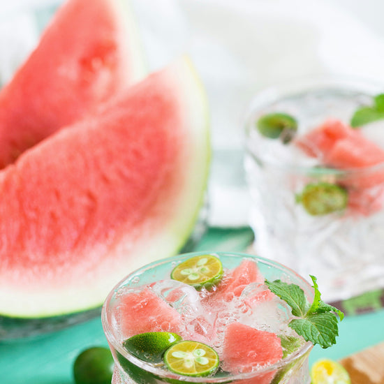 watermelon wedges and two cold drinks with mint, watermelon, ice cubes and finger lime slices