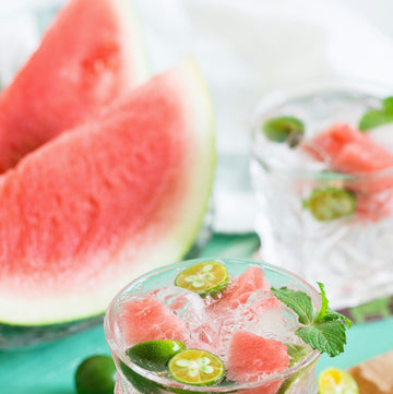 watermelon wedges and two cold drinks with mint, watermelon, ice cubes and finger lime slices