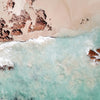 a shoreline with some rocks and crystal blue ocean water